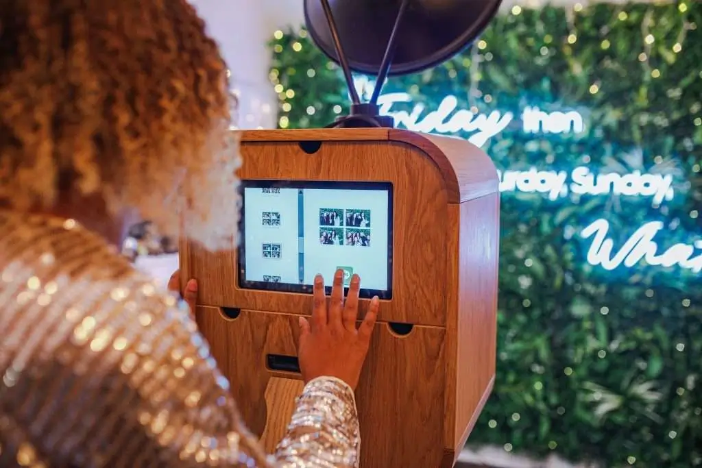 Guest interacting with a touchscreen photo booth at a vendor booth event