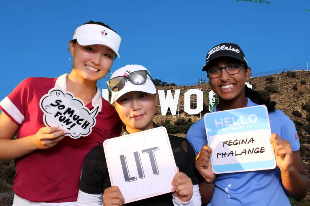Three guests posing with fun props in front of a themed Hollywood backdrop at a green screen photo booth
