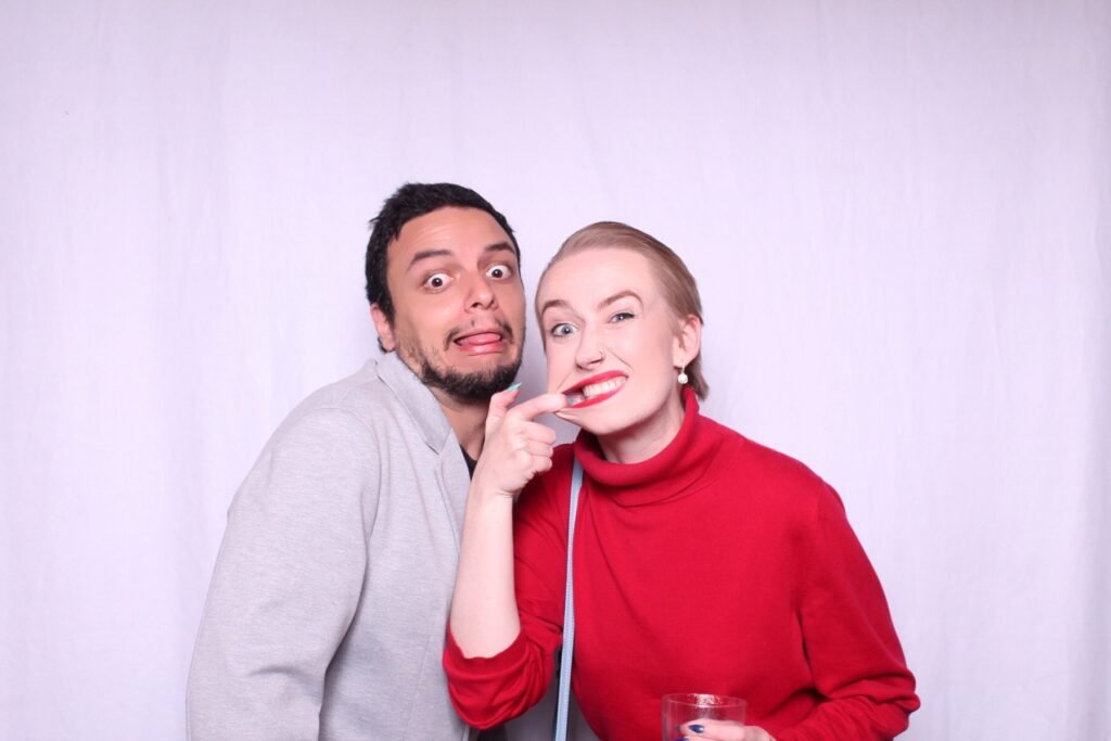 A playful duo making funny faces against a plain white backdrop.