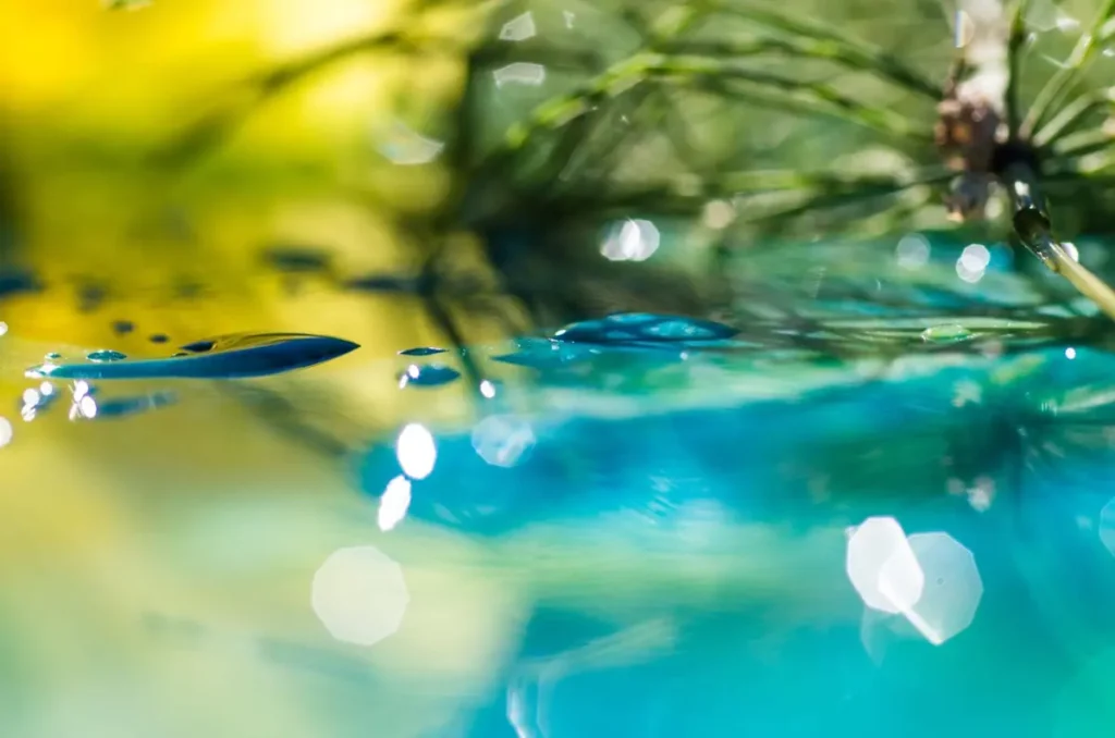 Abstract macro photography of water droplets with turquoise and yellow bokeh effects, highlighting creative nature photography