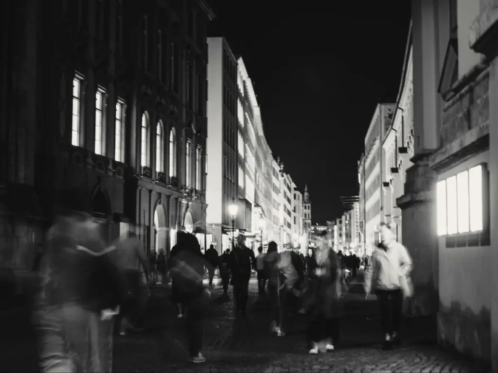 Black and white night street photography with motion blur capturing urban crowd movement