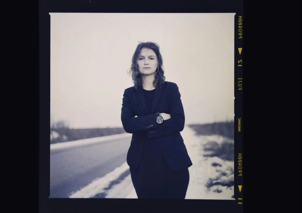 Black and white portrait photography with film aesthetic showing person in dark blazer, representing return to analog styles