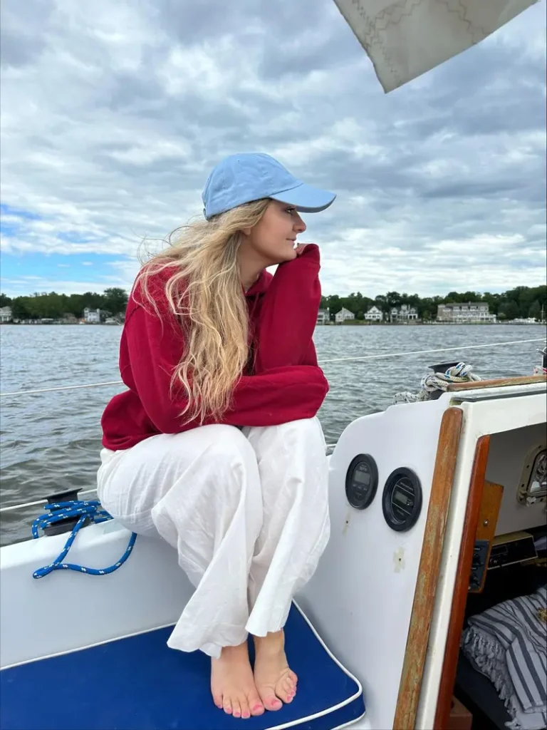 Lifestyle portrait of woman on sailboat with natural lighting, showcasing authentic outdoor photography trends