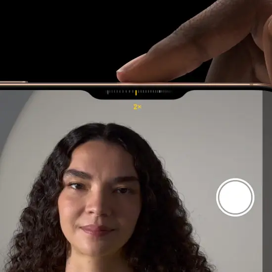 Smartphone camera interface with 2x zoom capturing woman with curly hair