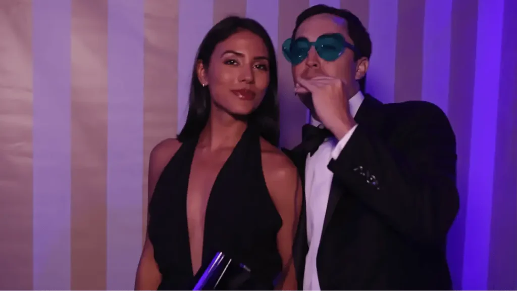 Two people posing at a formal event with purple lighting backdrop, showcasing authentic video testimonial moments