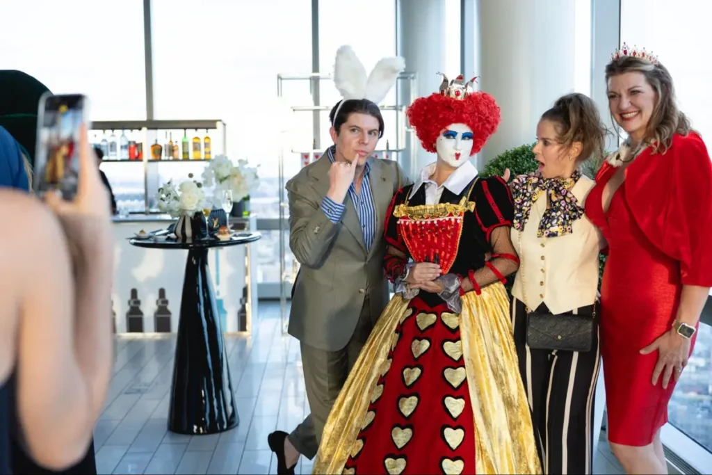 Alice in Wonderland costumed character posing with attendees at themed corporate event, offering interactive photo opportunities