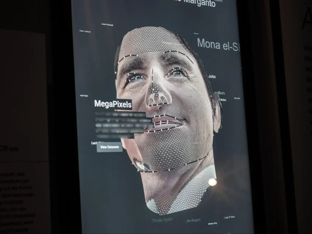 Digital facial mapping interface showing mesh overlay on a human face with MegaPixels label, demonstrating AI recognition technology