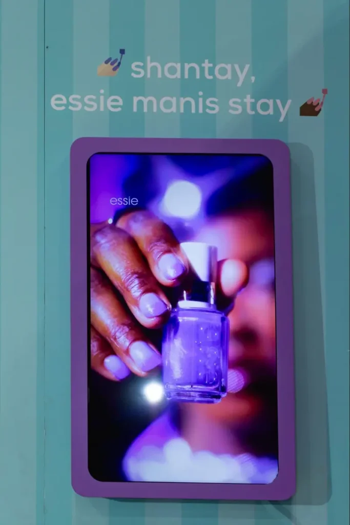 Essie nail polish LED display with purple nail polish bottle and branded tagline 'shantay, essie manis stay' for beauty event