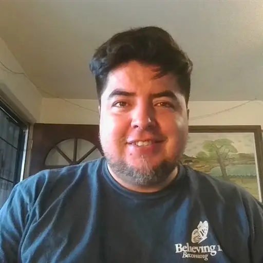 Man smiling at camera in casual blue t-shirt with butterfly logo, representing an event participant or photo activation user