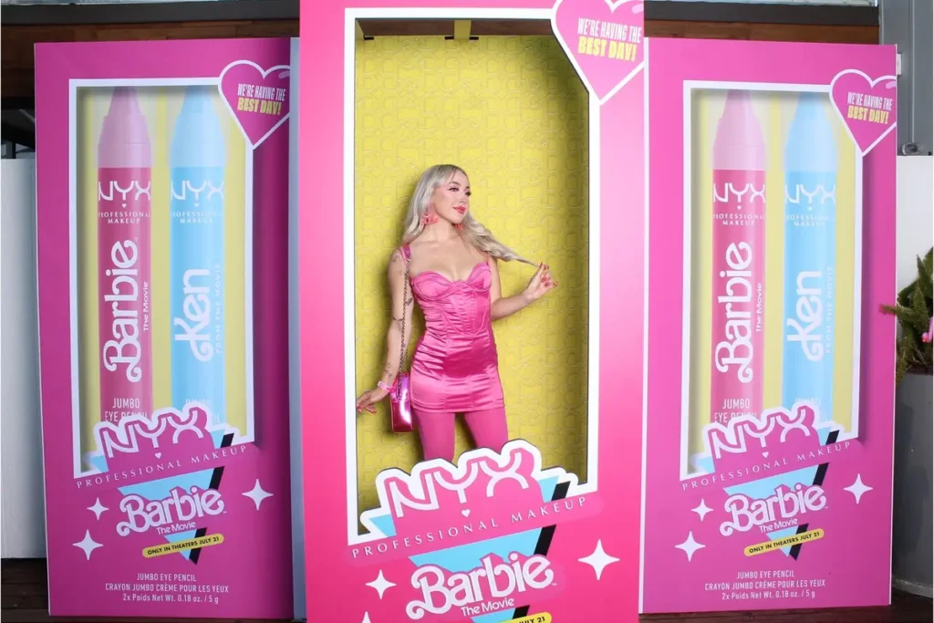 NYX x Barbie movie collaboration photo booth with life-size packaging design featuring branded makeup pencils and doll box staging