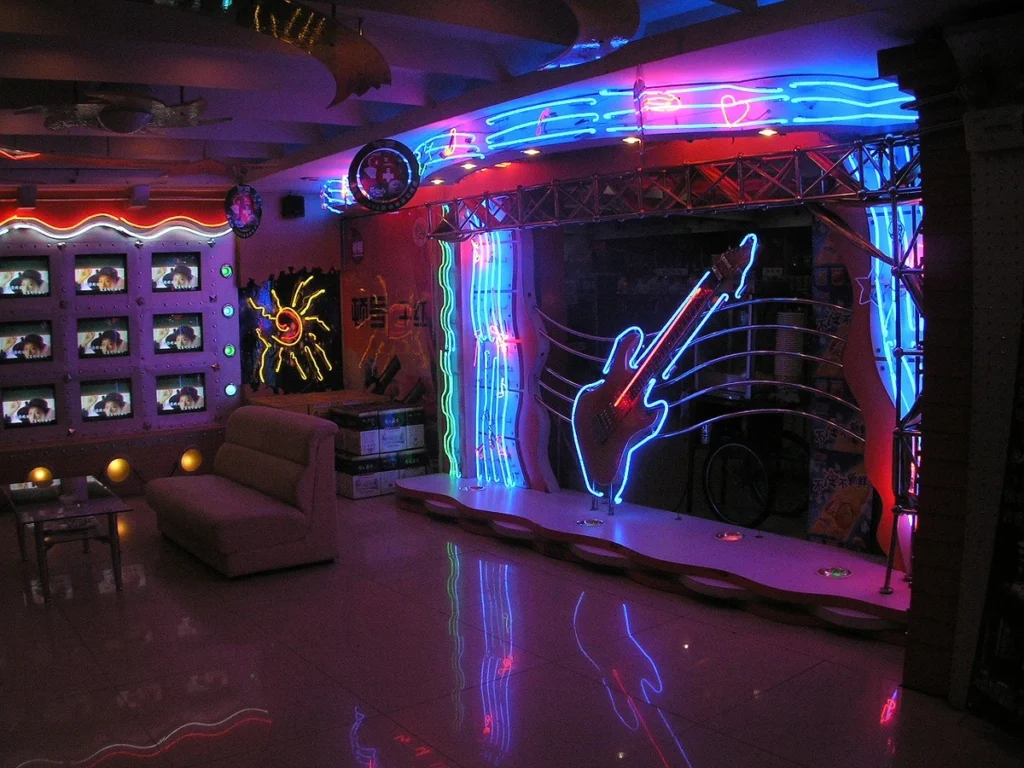 Rock-themed event space with neon guitar sign and colorful lighting, perfect for music-themed corporate entertainment experiences