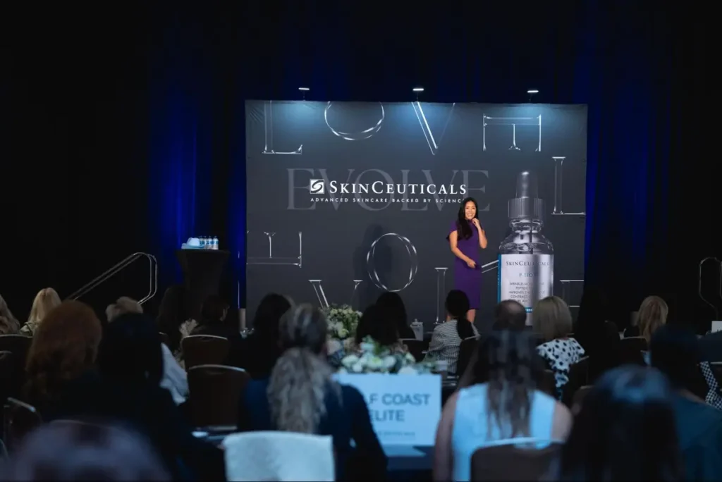 SkinCeuticals corporate presentation with speaker at podium, demonstrating professional brand activation at corporate event
