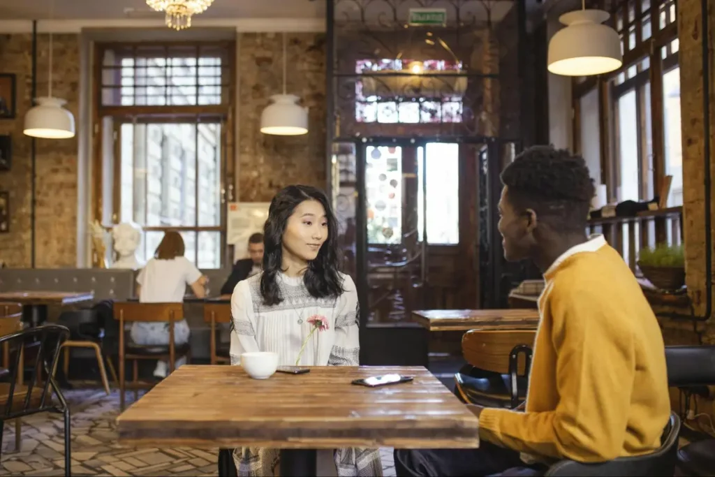 Couple enjoying conversation at a rustic café with exposed brick walls, perfect for intimate gatherings or coffee house themed events