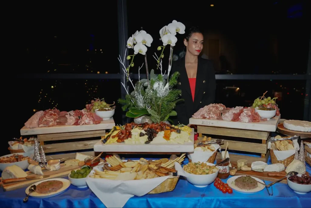 Elegant charcuterie and cheese display with white orchids for upscale events, featuring a variety of gourmet appetizers