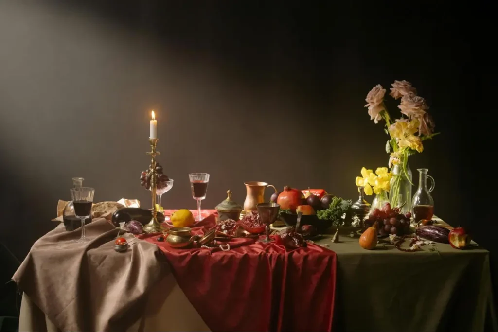 Elegant still life table setting with candlelight, flowers and fruits, inspiration for Renaissance or historical dining events