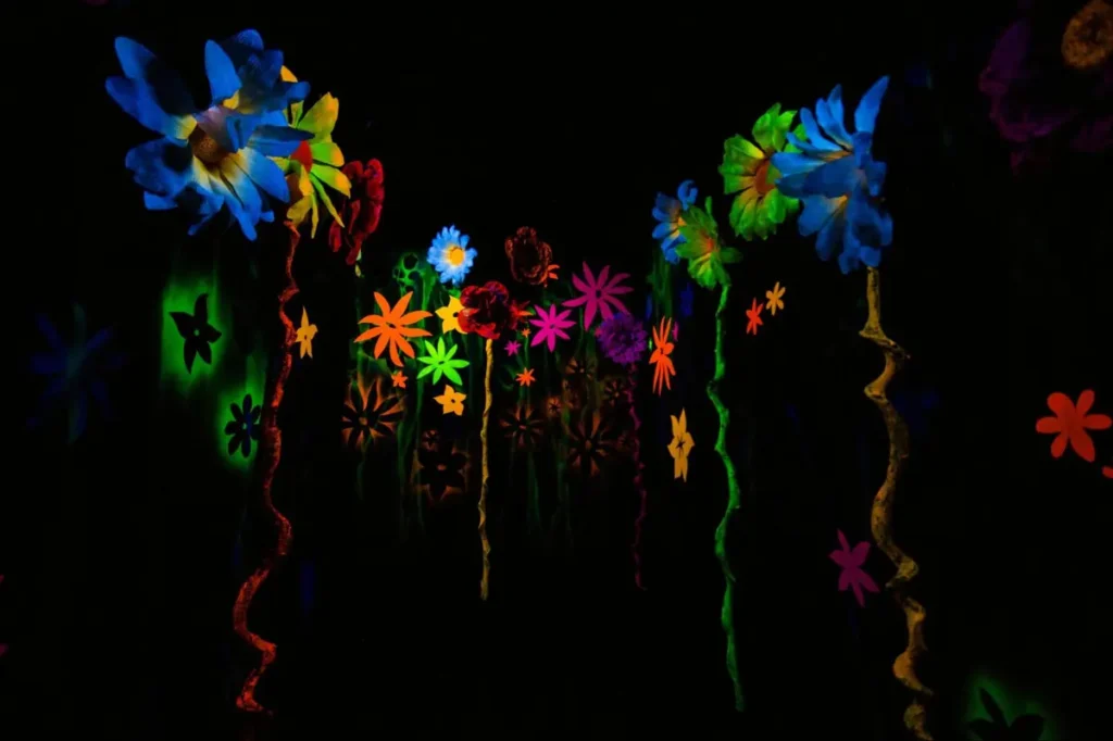 Fluorescent flowers glowing in blacklight, ideal inspiration for neon glow party or psychedelic art installation events