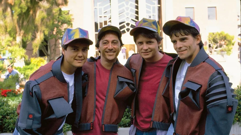 Four men in futuristic matching jackets and holographic caps for a Back to the Future themed event