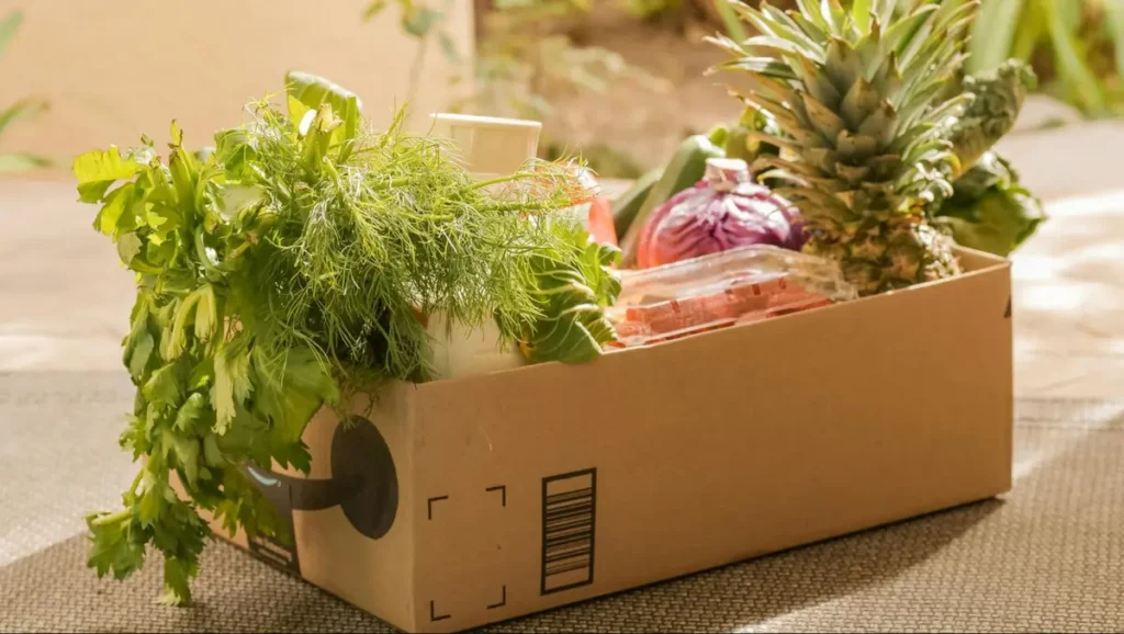 Fresh produce box with vegetables, herbs and pineapple - farm-to-table catering option for sustainable event themes