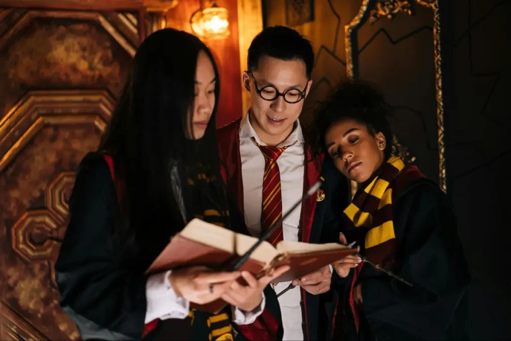 Harry Potter themed event with students in Hogwarts house scarves reading spellbooks in ornate castle-like setting