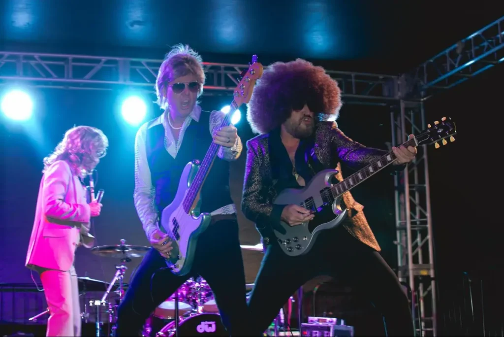 Rock band tribute performers on stage with colorful lighting, perfect for music-themed corporate events or retro parties