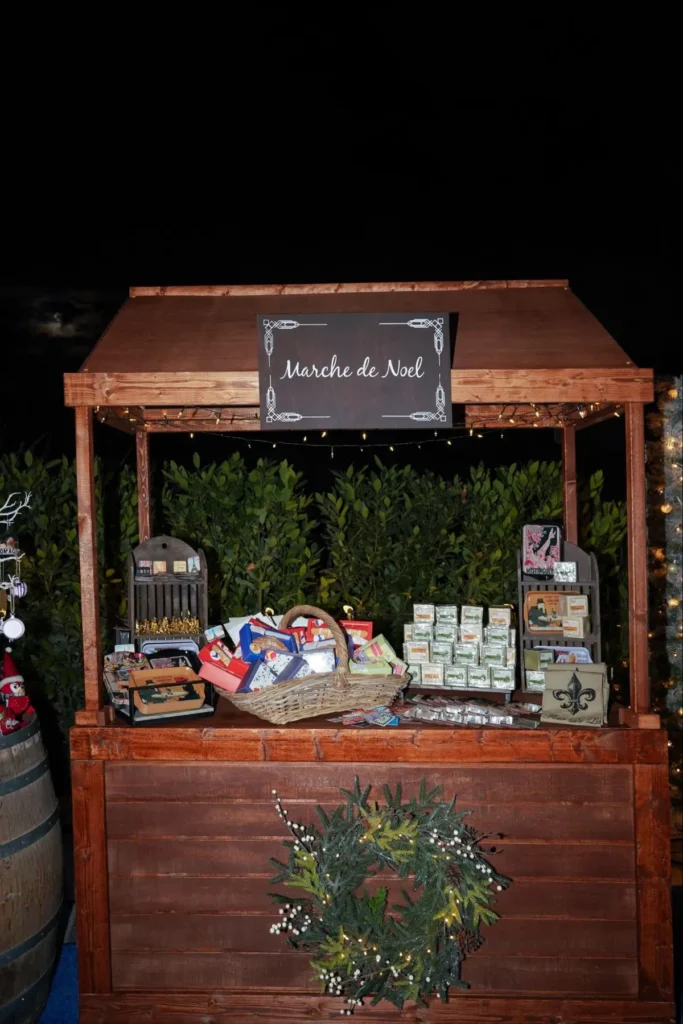 Rustic wooden Christmas market stall with 'Marche de Noel' sign - Holiday themed marketplace with festive decorations and products