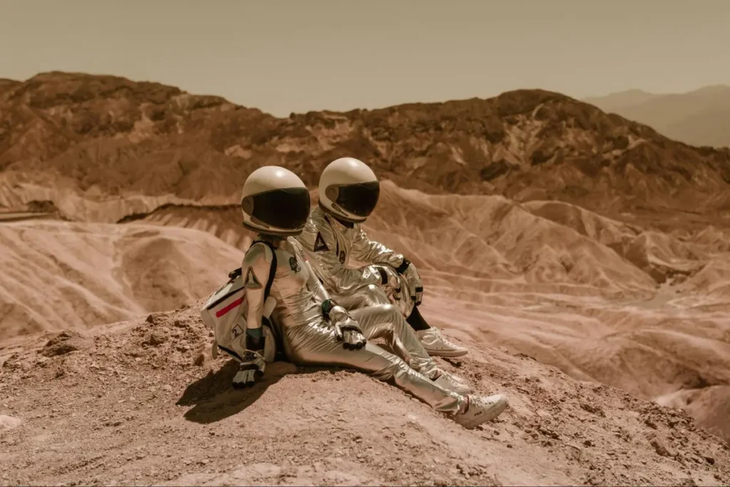 Space exploration themed couple photoshoot with astronaut suits against Mars-like landscape
