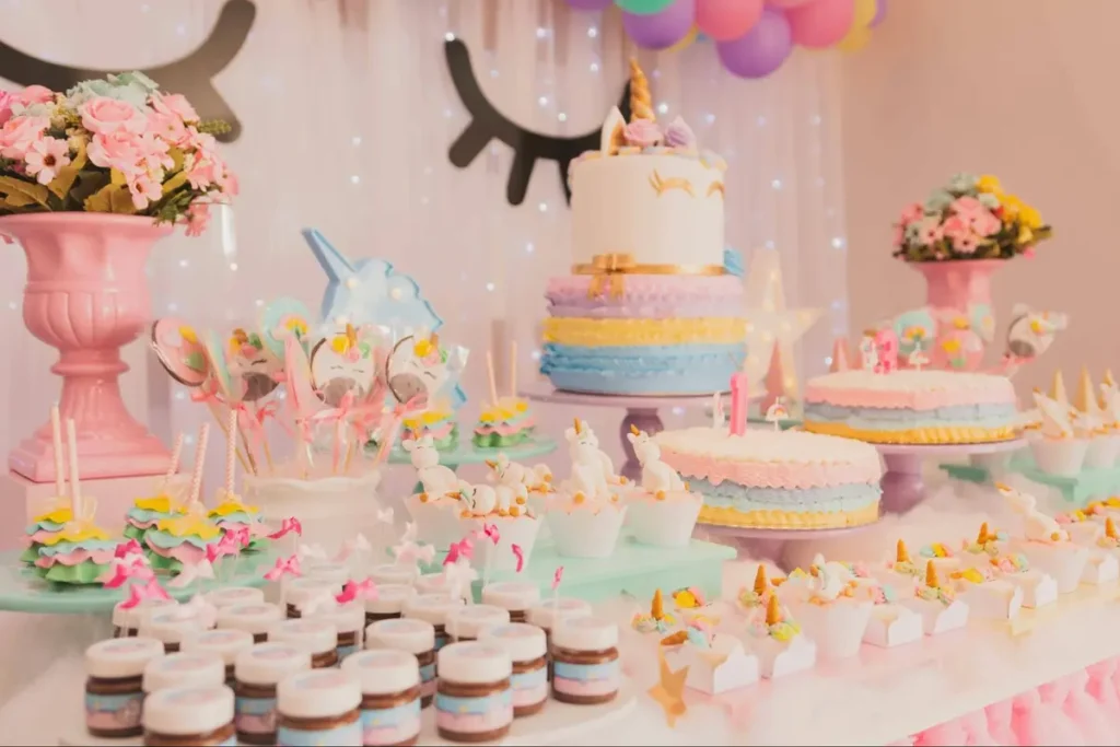 Unicorn-themed dessert table with pastel cakes, cupcakes and themed treats perfect for children's birthday parties