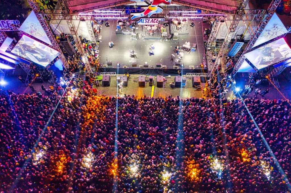 Aerial photo of a packed live concert crowd and stage, showcasing event coverage for brands