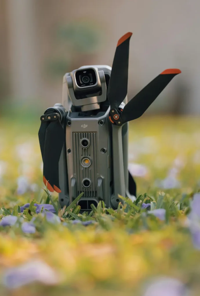 Compact DJI drone with folded propellers resting on a grassy field, ready for commercial aerial photography
