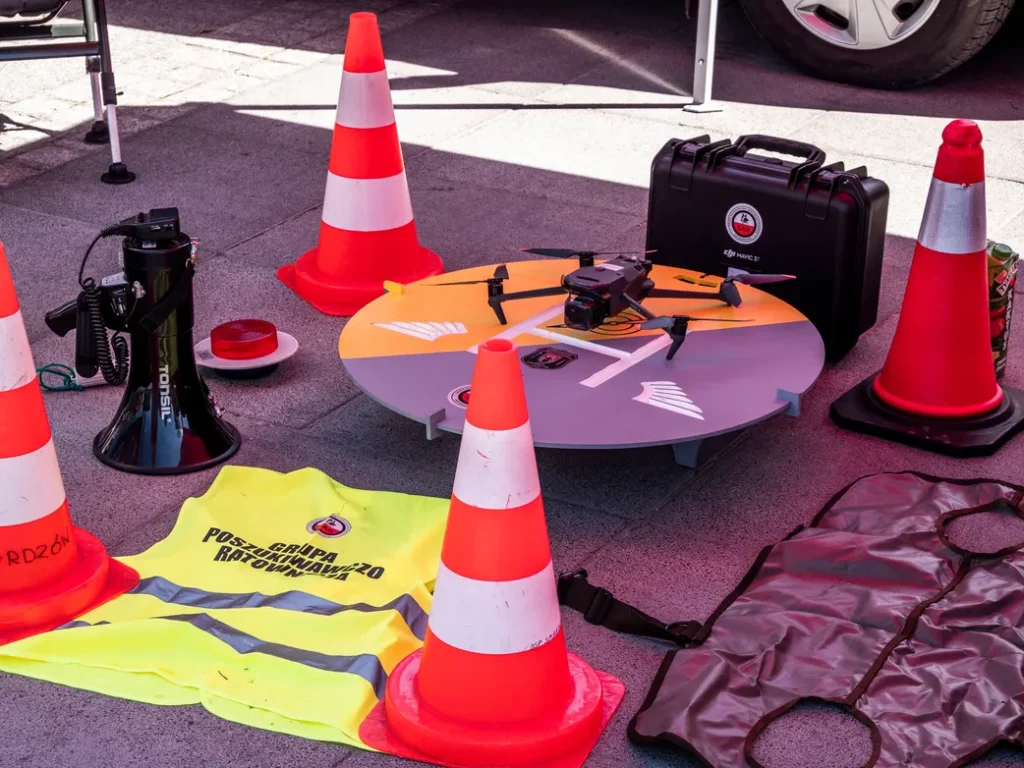 Commercial drone safety equipment including landing pad, traffic cones, safety vest, and drone case used during professional aerial photography operations