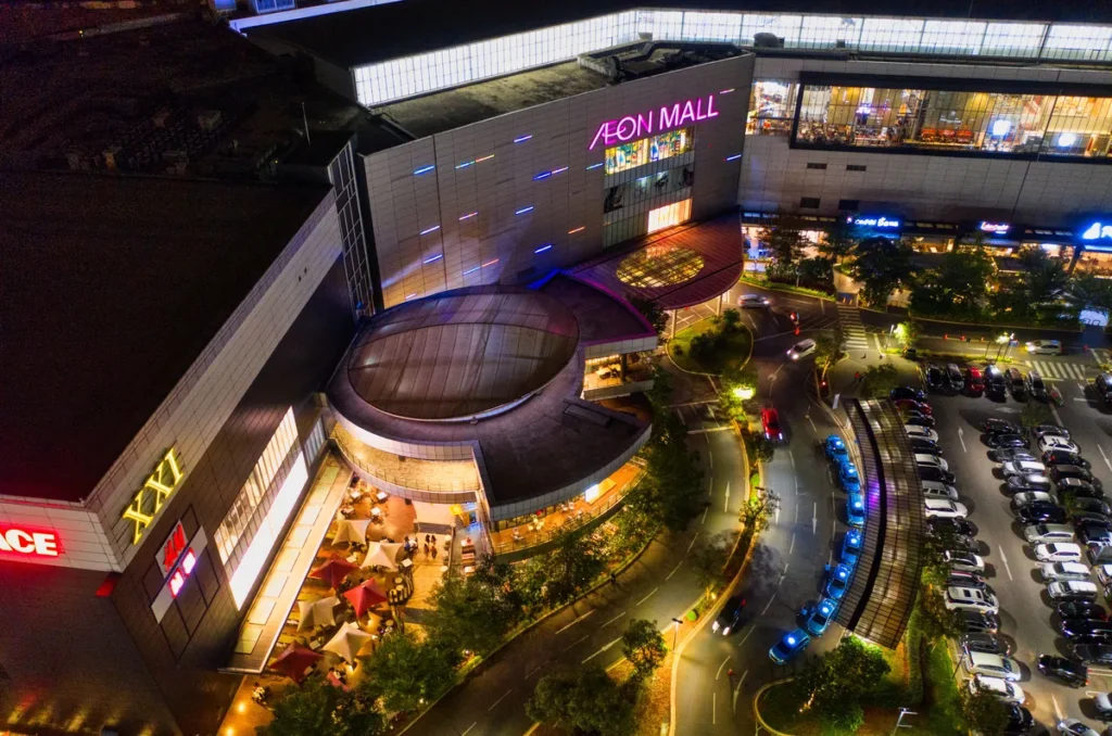 Aerial drone photography of a busy shopping mall capturing retail traffic, storefronts, parking areas, and commercial property for marketing campaigns.